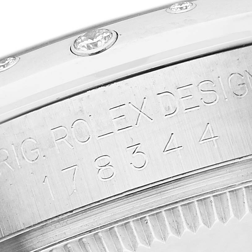 The image shows a close-up of the bezel and engraved serial number on a mid-size Rolex watch.