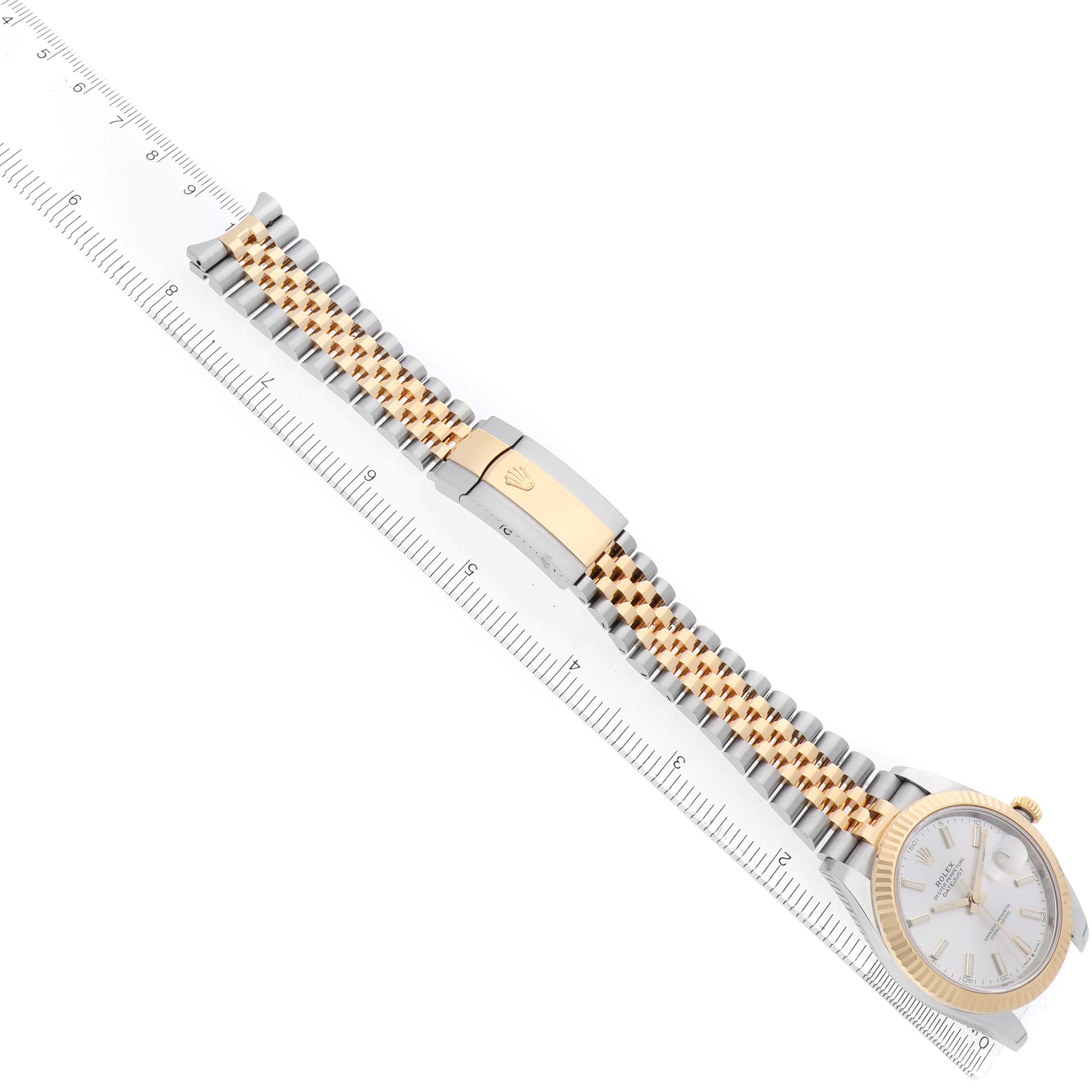 The image shows a Rolex Datejust 41 126333 Men
s Steel and Gold (two tone) Silver Dial with a two-tone bracelet, clasp, and part of the watch face, angled diagonally across a ruler.