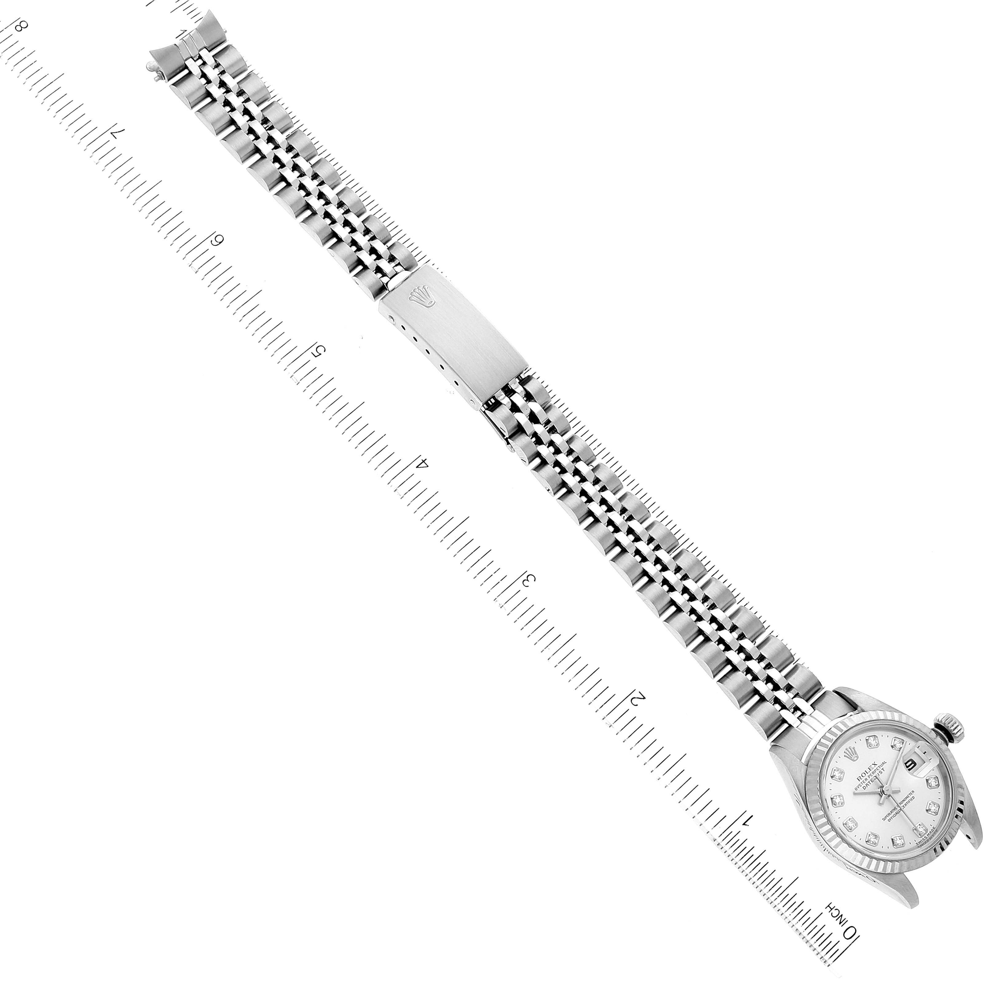 The image shows a top view of the Rolex Datejust 79174 Women's Stainless Steel Silver Dial 79174 Women's Stainless Steel Silver Dial watch, highlighting its bracelet and face, with a ruler for scale.