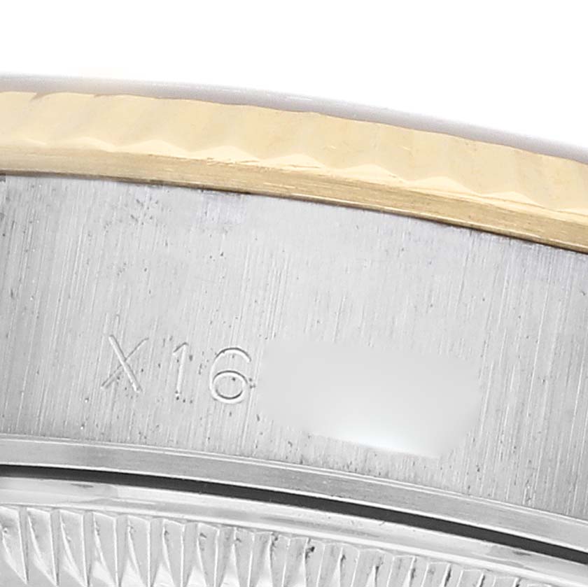 The image shows a close-up of the bezel and part of the case side of a Rolex Datejust 69173 Women
s Steel and Gold (two tone) Champagne Dial, highlighting its engraved markings.