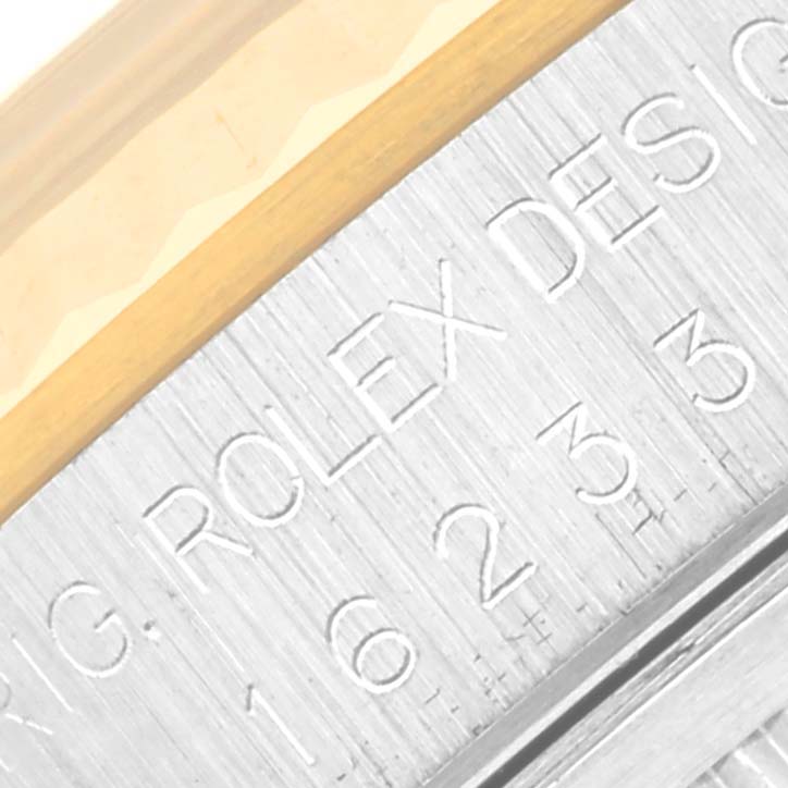 The image shows a close-up of the side engraving and part of the bezel of the Rolex Datejust 16233 Men's Steel and Gold (two tone) Champagne Dial 16233 Men's Steel and Gold (two tone) Champagne Dial watch.