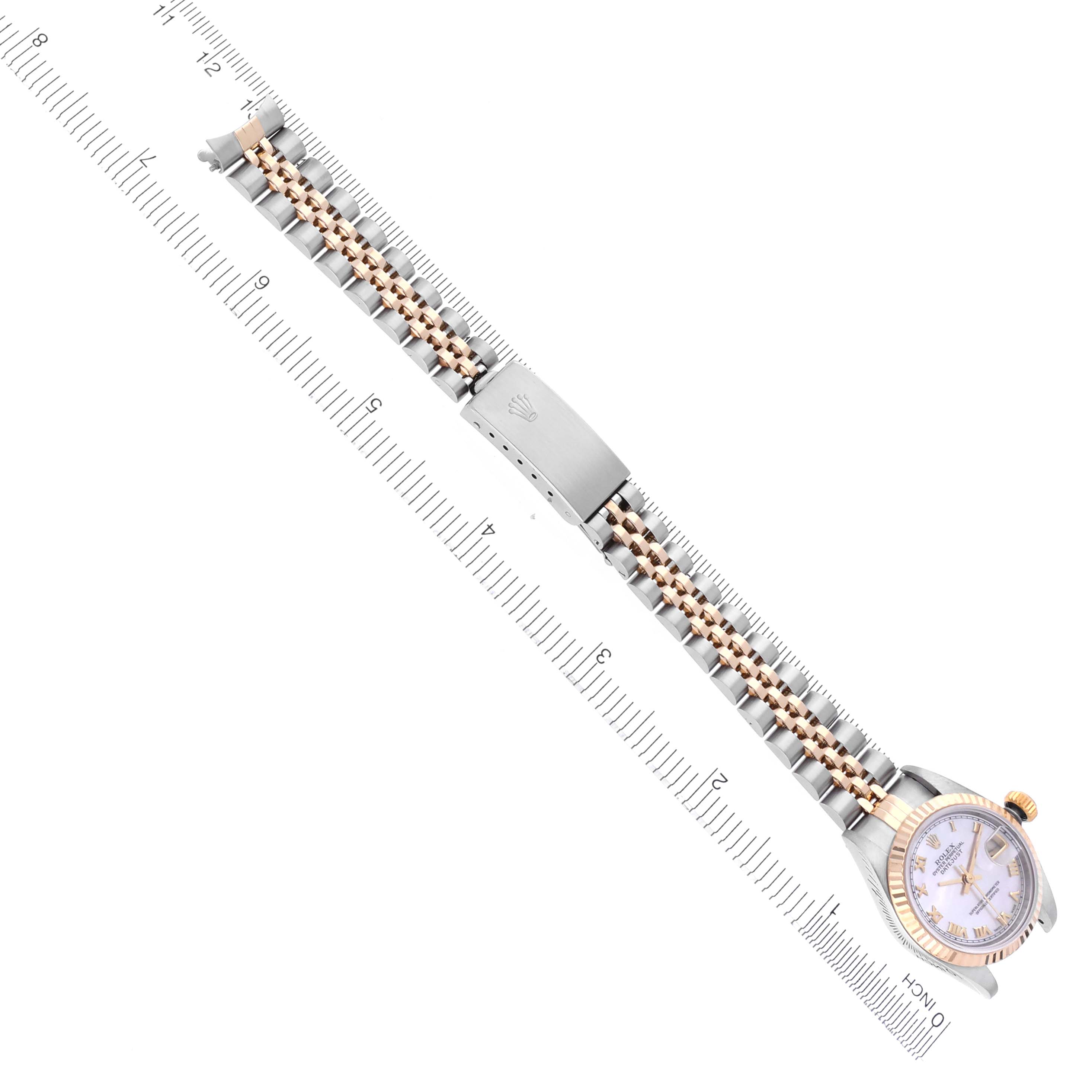 The Rolex Datejust 79173 Women's Steel and Gold (two tone) Mother of Pearl Dial 79173 Women's Steel and Gold (two tone) Mother of Pearl Dial watch is shown from a top view, featuring its full strap and face alongside a measuring ruler.