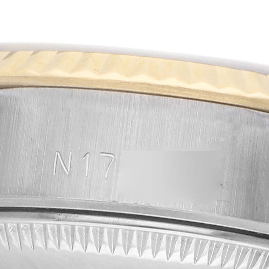 The image shows a partial close-up of the case side and bezel of a Rolex Datejust 69173 Women
s Steel and Gold (two tone) White Dial watch, highlighting the edge detail and engraved markings.