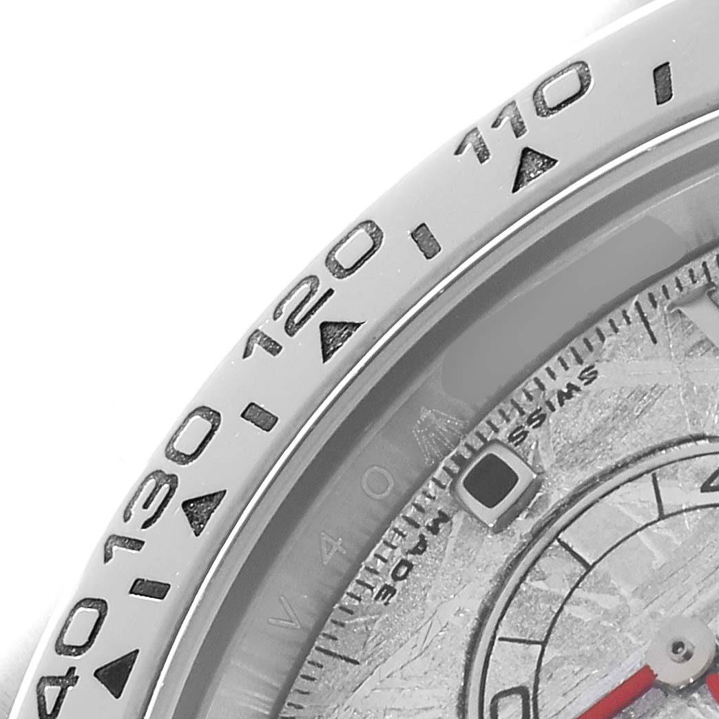 The image shows a close-up of the Rolex Daytona 116509 Men
s White Gold Silver Dial
s bezel with tachymetric scale and part of the dial.