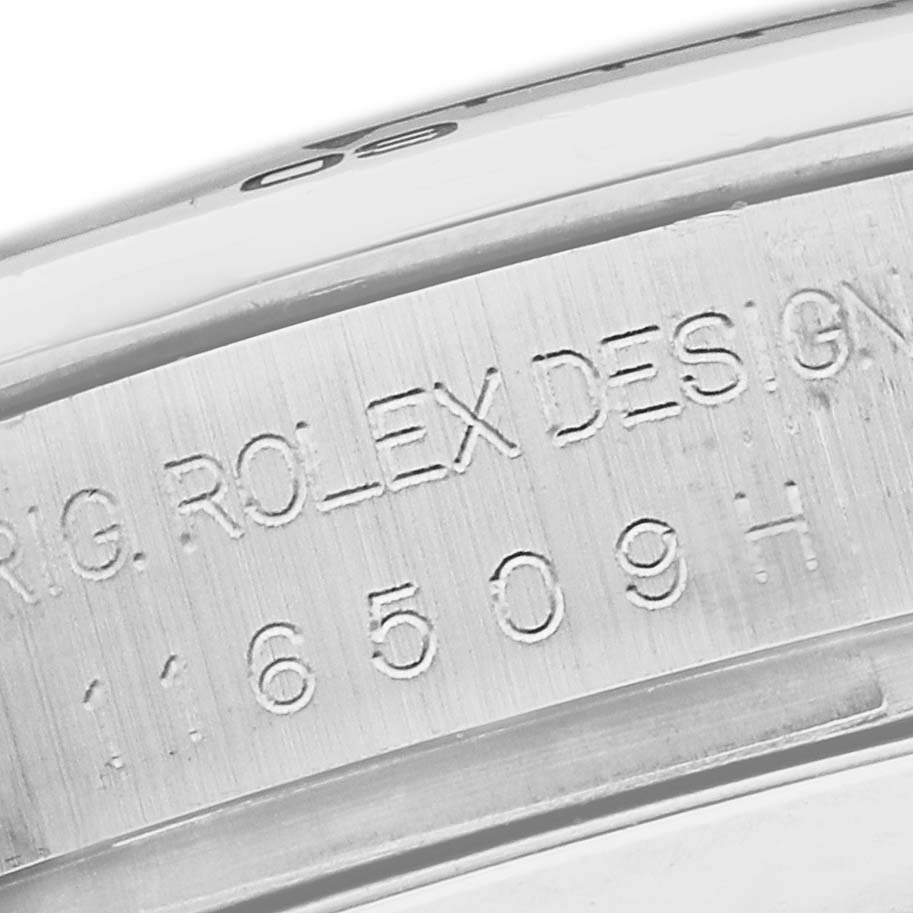 The image shows a close-up of the Rolex Daytona 116509 Men
s White Gold Silver Dial model
s case side, featuring engraved details and serial numbers.