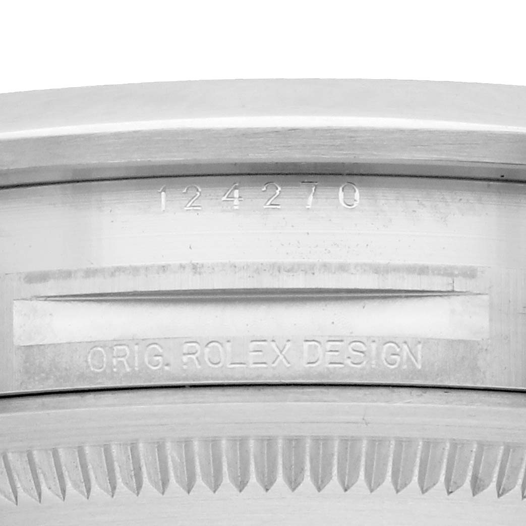 The image shows a close-up of the case side of a Rolex Explorer 124270 Men
s Stainless Steel Black Dial, highlighting the engraved serial number and "ORIG. ROLEX DESIGN."