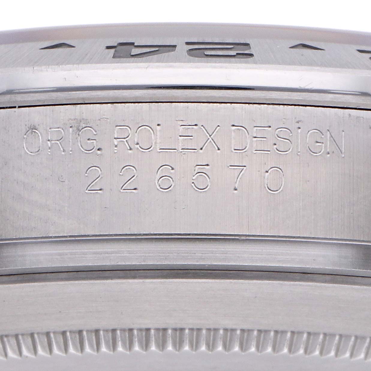 The image shows a close-up of the side of a Rolex Explorer 226570 Men
s Stainless Steel White Dial, focusing on the bezel and engraved case details.