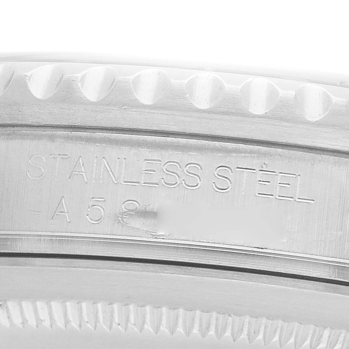 The image shows a close-up of the engraved case side of a Rolex GMT-Master 16700 Men
s Stainless Steel Black Dial, displaying "STAINLESS STEEL."