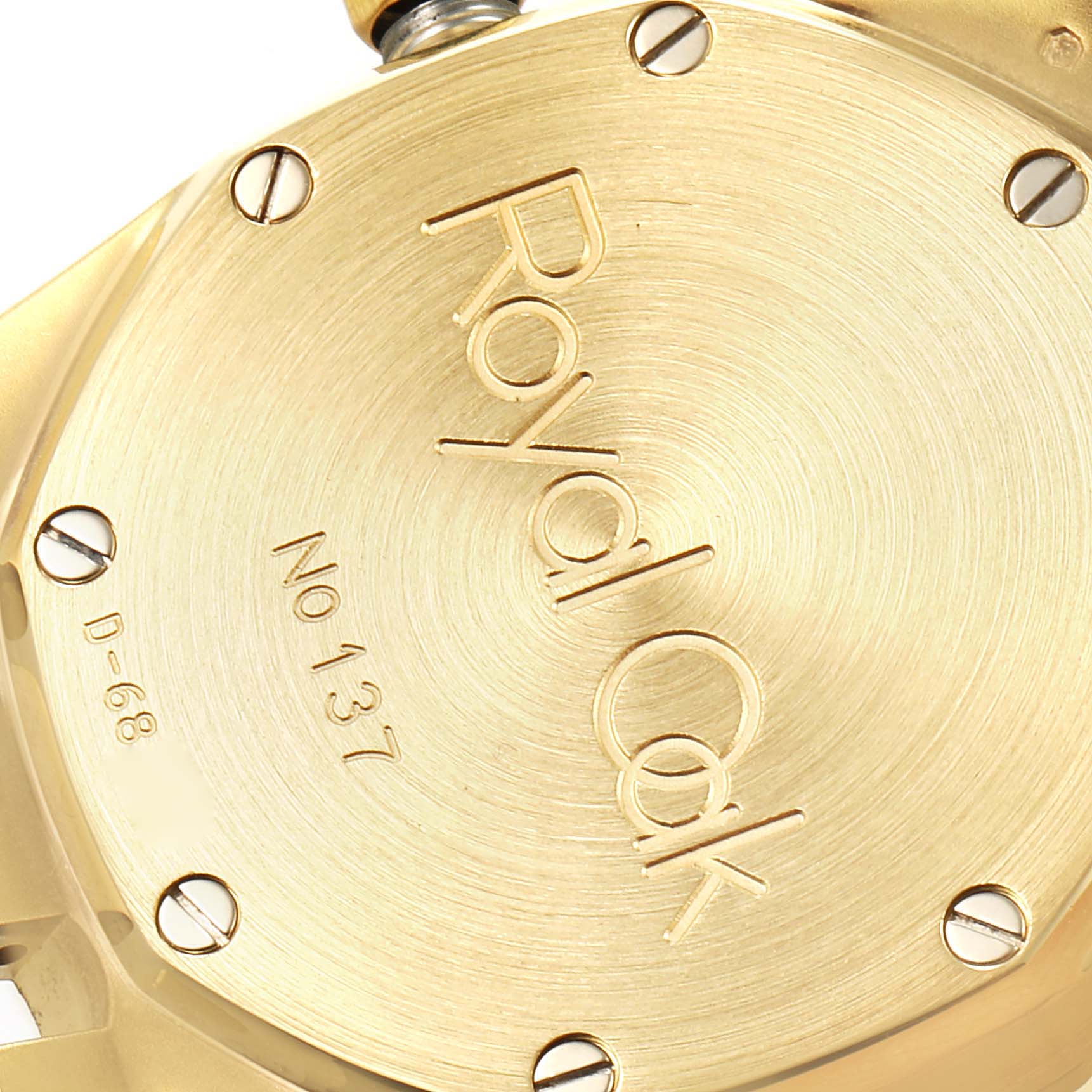 Close-up angle of the Audemars Piguet Royal Oak 15000BA Men's Yellow Gold Champagne Dial 15000BA Men's Yellow Gold Champagne Dial watch's gold back case, showing screws and engraved text.