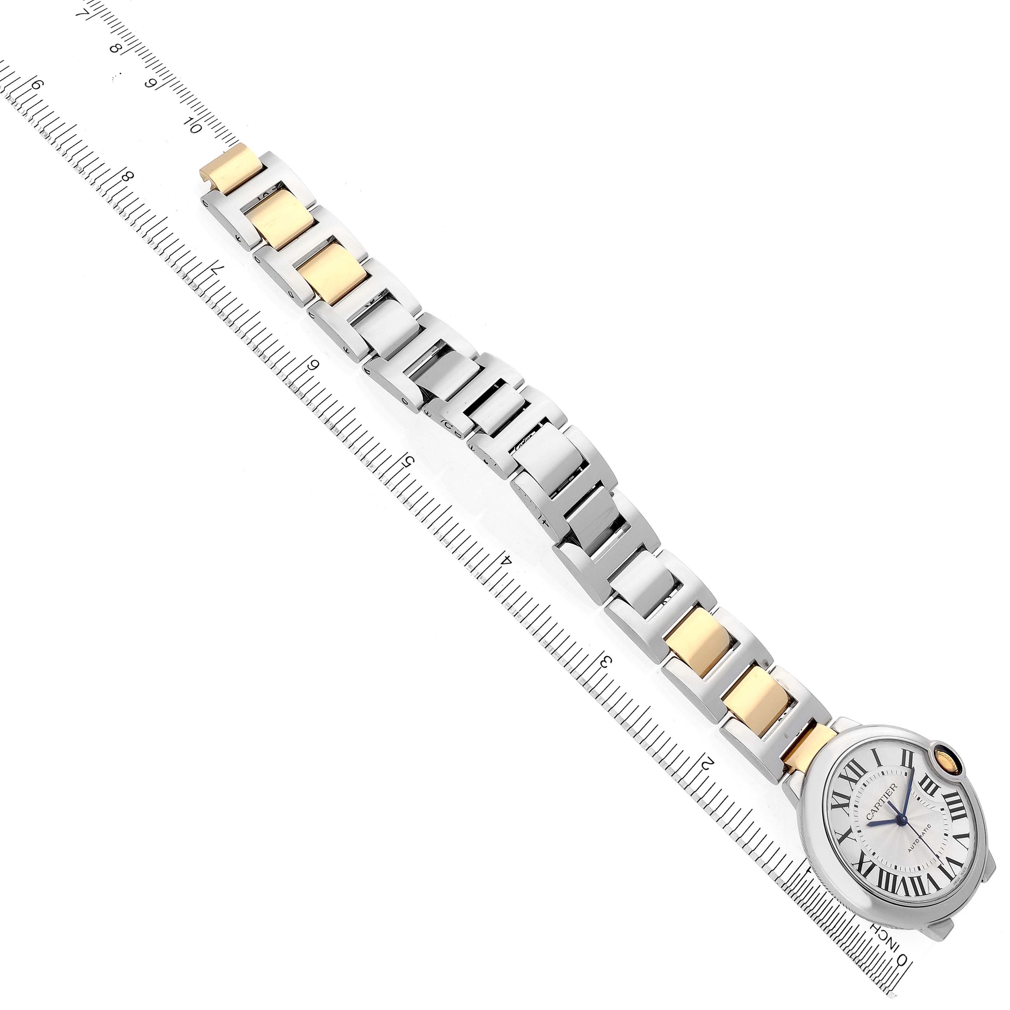 The Cartier Ballon Bleu W2BB0012 Women's Steel and Gold (two tone) Silver Dial W2BB0012 Women's Steel and Gold (two tone) Silver Dial watch is shown at an angled side view, displaying the full bracelet and face alongside a ruler for scale.