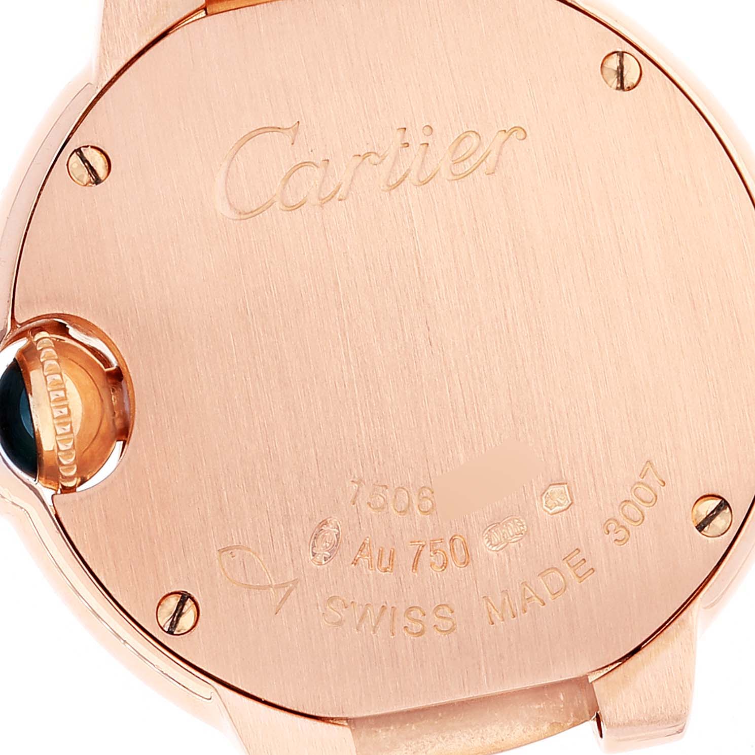 The image shows the back case of the Ballon Bleu watch by Cartier, featuring engravings and a crown with a blue gemstone.