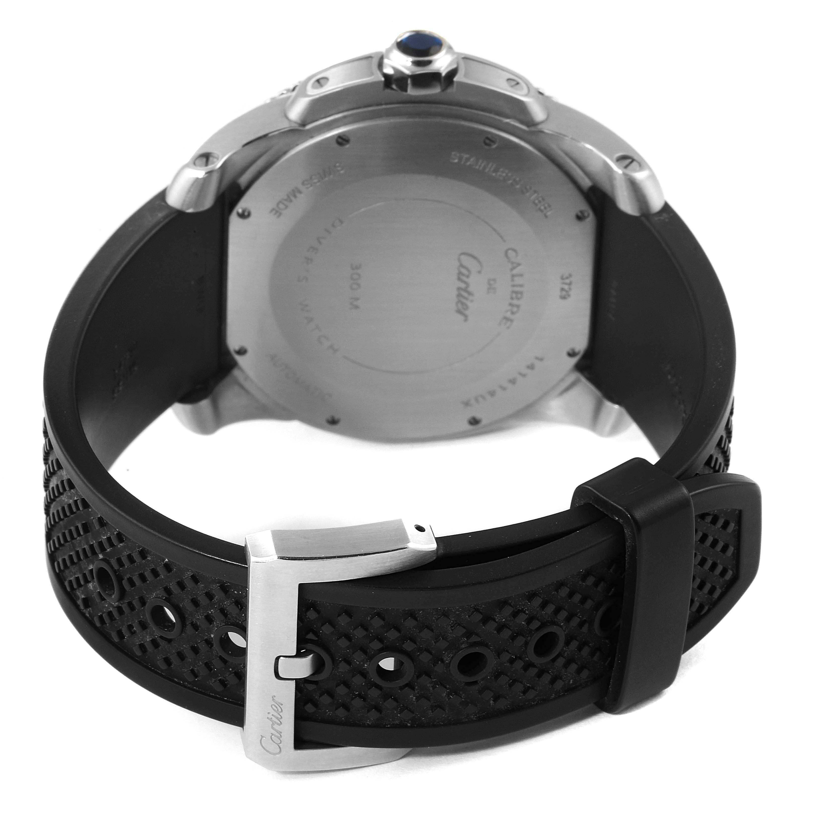 The image shows the back of a Calibre de Cartier watch by Cartier, highlighting the case back, rubber strap, and buckle.