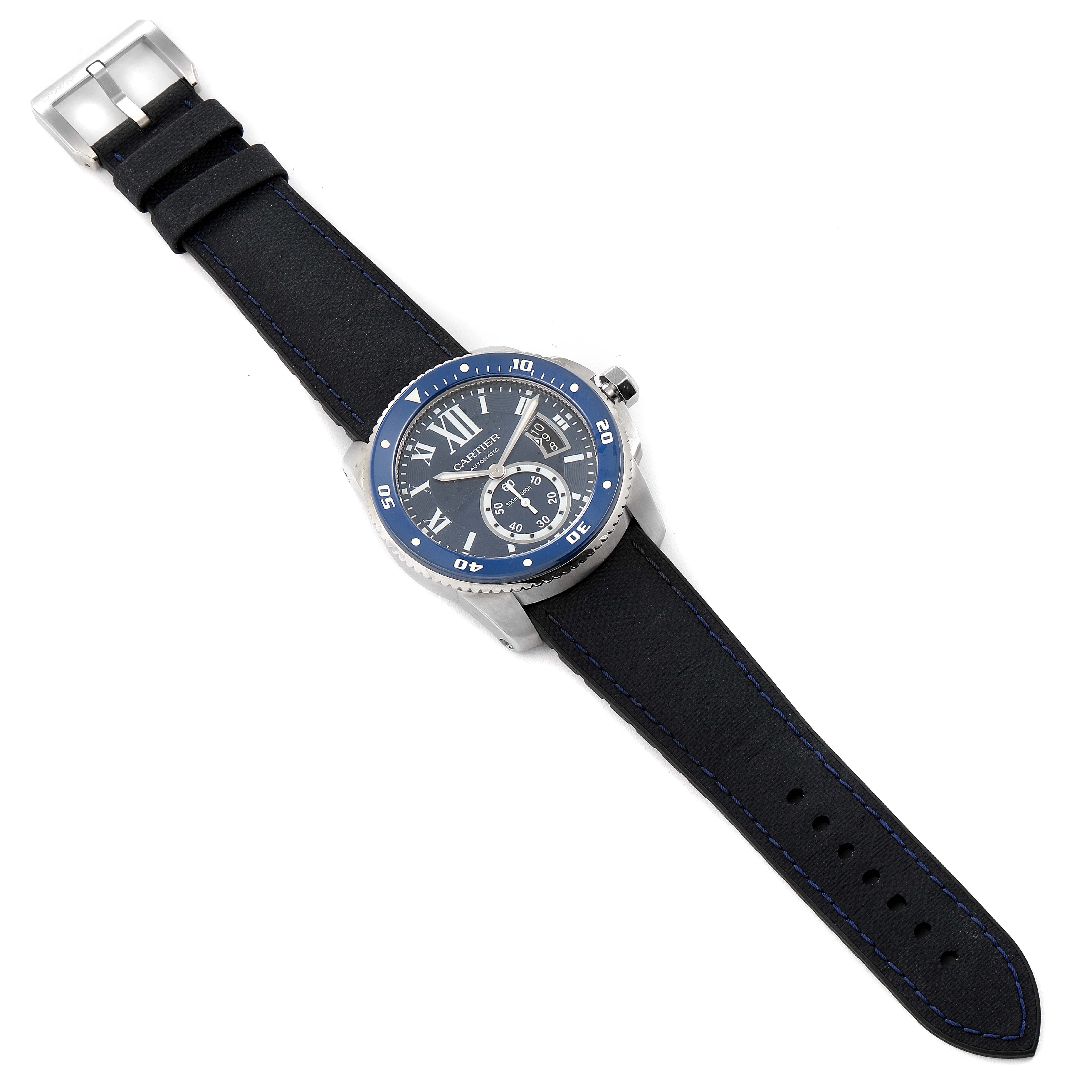 The Calibre de Cartier watch by Cartier is shown from a top-down angle, displaying the face, bezel, crown, and strap.