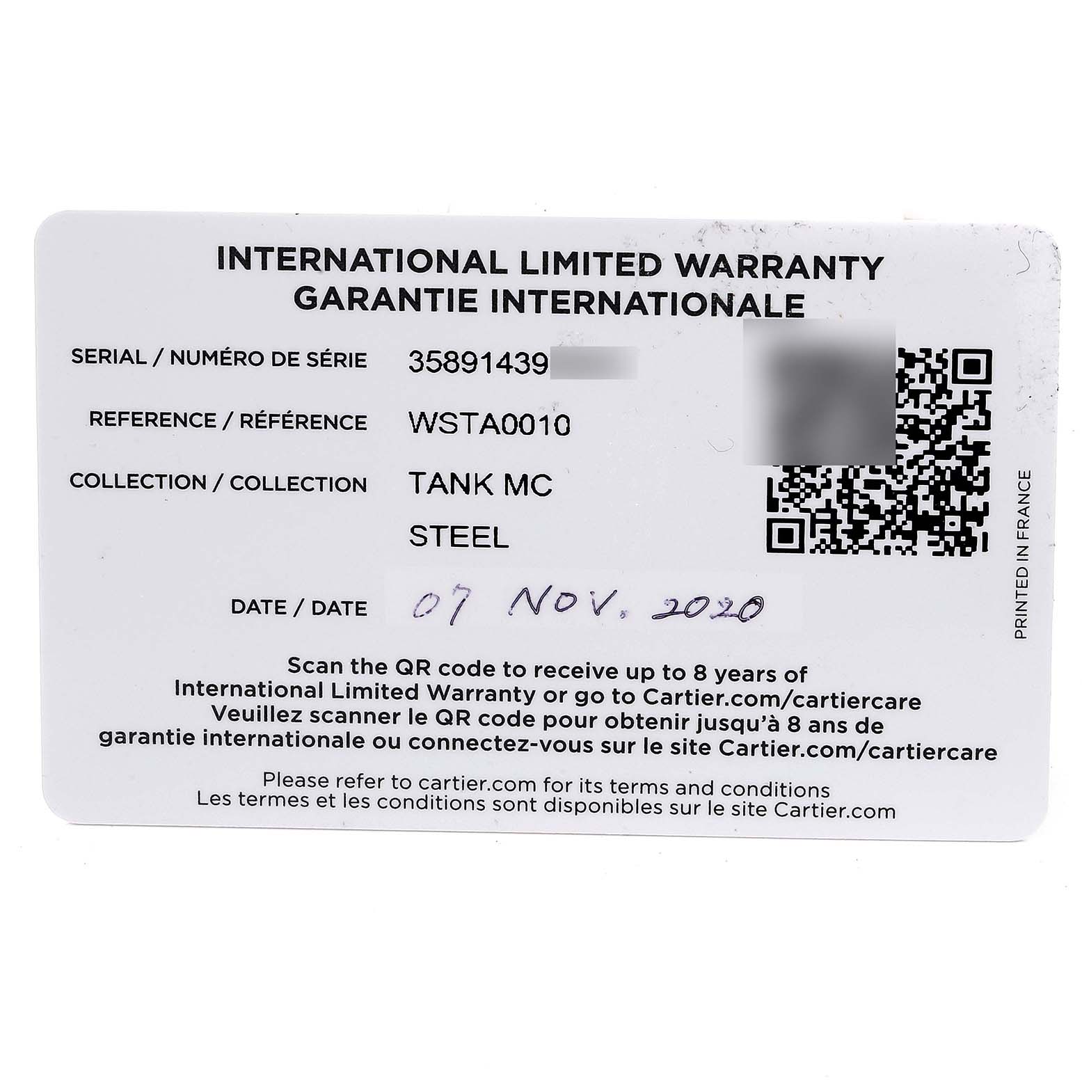 The image shows an international limited warranty card for the Cartier Tank MC WSTA0010 Men's Stainless Steel Blue Dial WSTA0010 Men's Stainless Steel Blue Dial model watch.