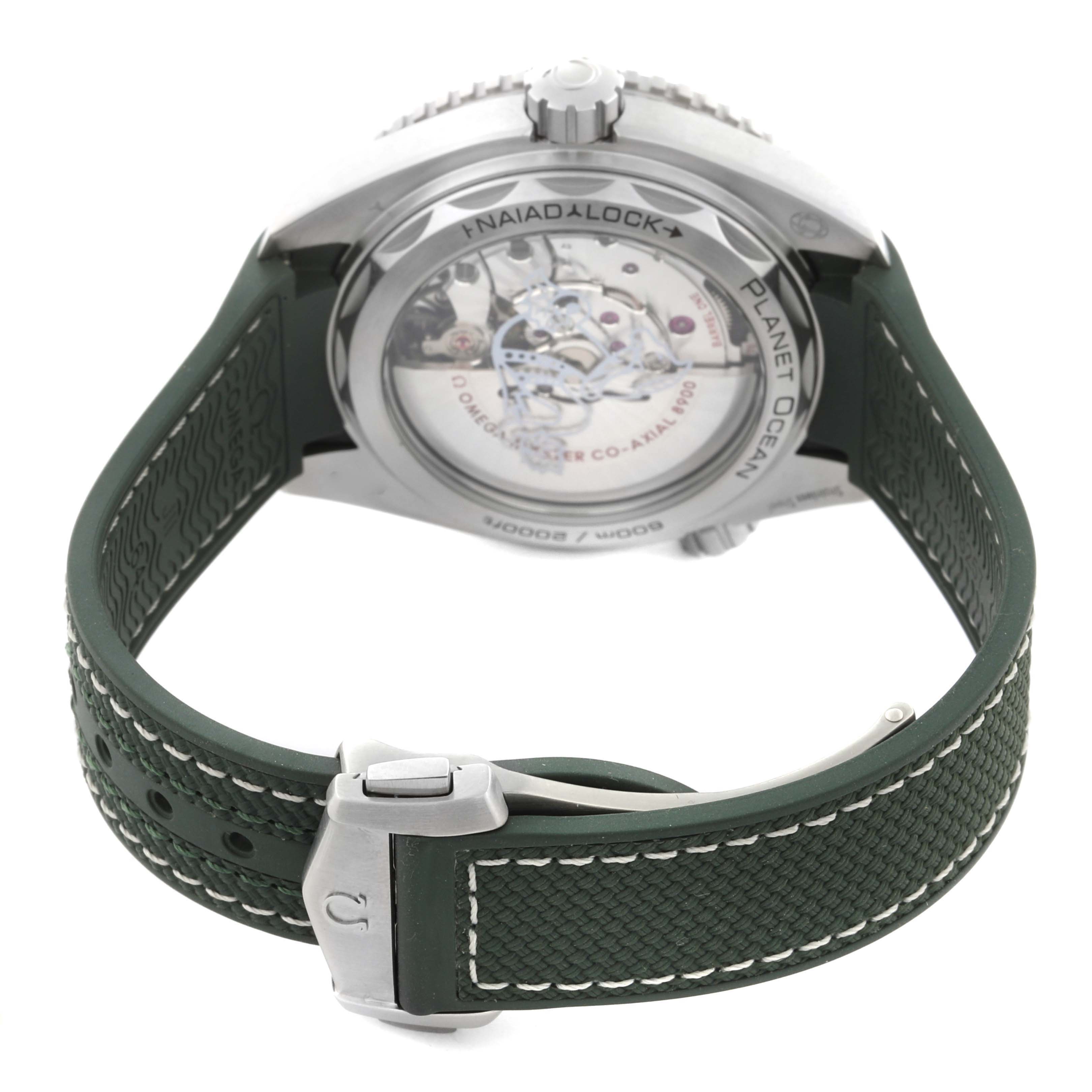 The image shows the back and side of the Omega Planet Ocean 215.32.44.21.06.001 Men's Stainless Steel Grey Dial 215.32.44.21.06.001 Men's Stainless Steel Grey Dial watch with a visible movement and green strap.