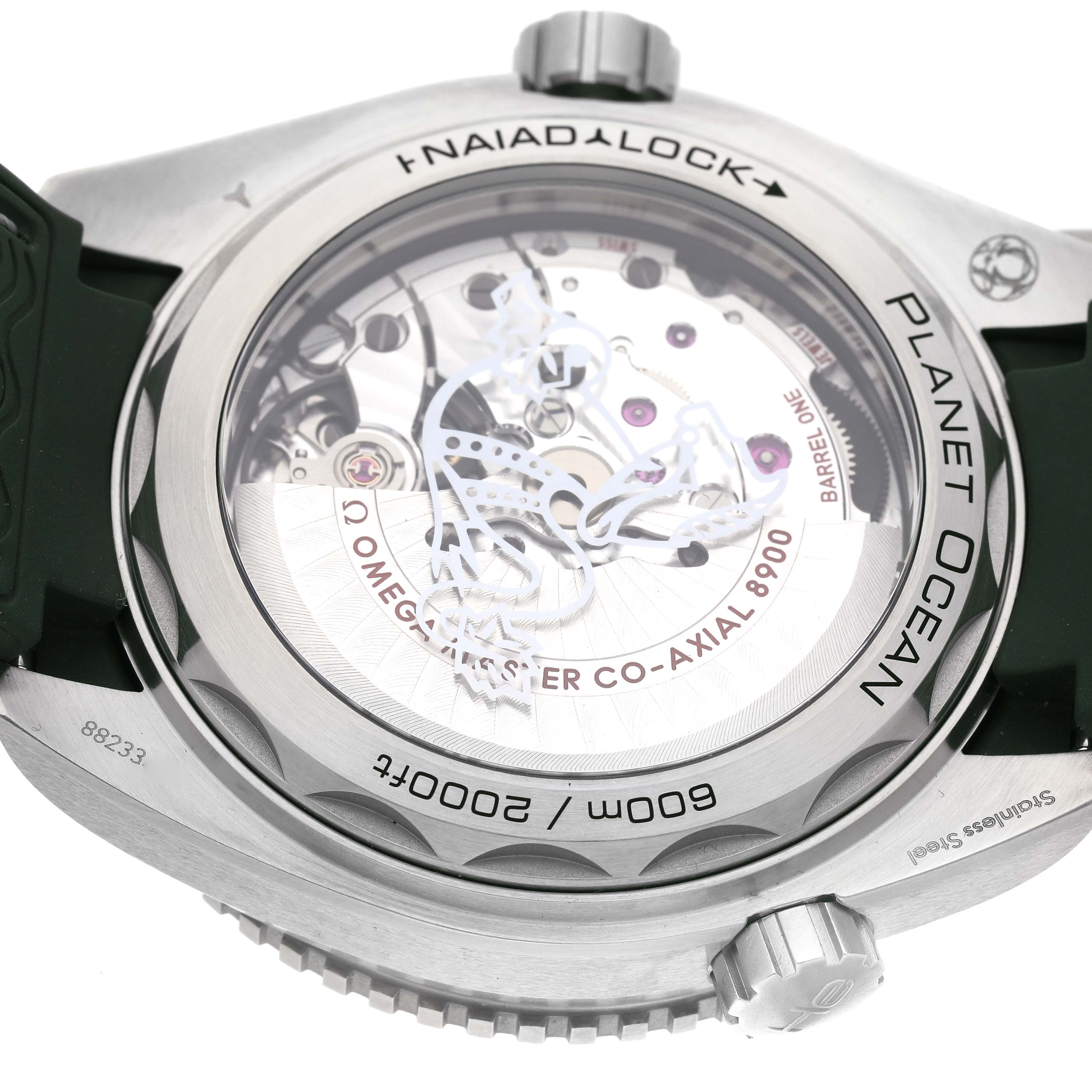 The image shows the back case of an Omega Planet Ocean 215.32.44.21.06.001 Men's Stainless Steel Grey Dial 215.32.44.21.06.001 Men's Stainless Steel Grey Dial watch, highlighting the movement and "Naiad Lock" feature.