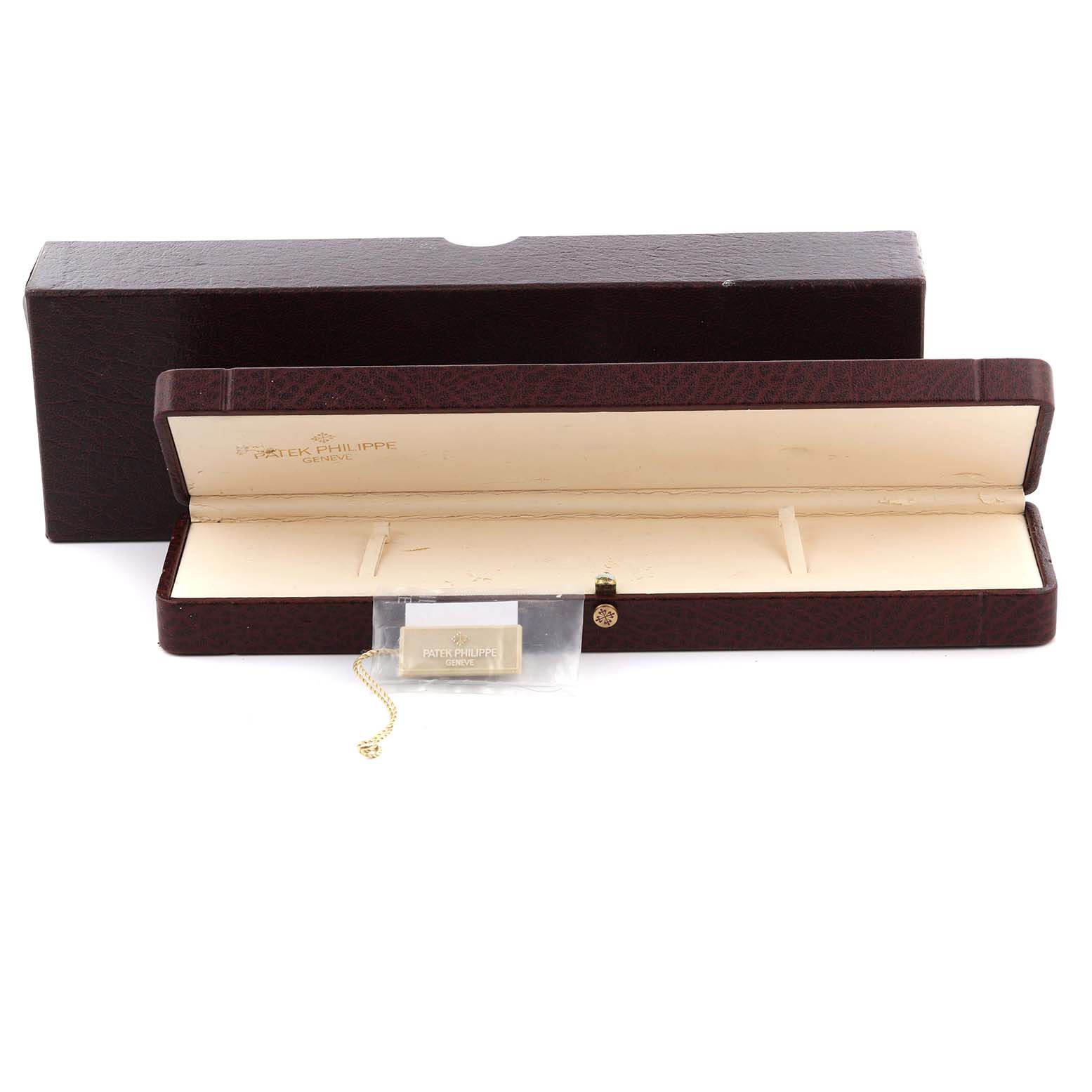 The image shows an open, empty Patek Philippe Calatrava 5127R-001 Men's Rose Gold Silver Dial 5127R-001 Men's Rose Gold Silver Dial watch box and a tag with the brand logo.