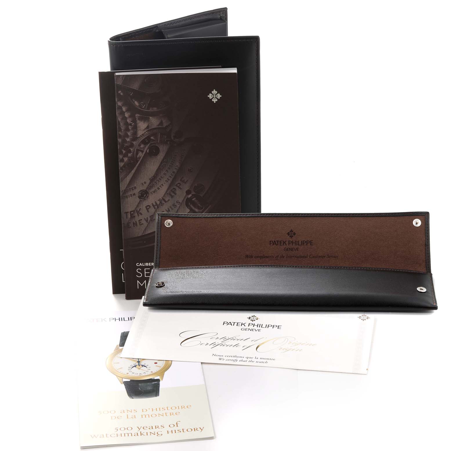 The image shows the accessories for the Patek Philippe Golden Ellipse 5738R-001 Men's Rose Gold Black Dial 5738R-001 Men's Rose Gold Black Dial model, including a booklet, warranty, certificate, and leather case.