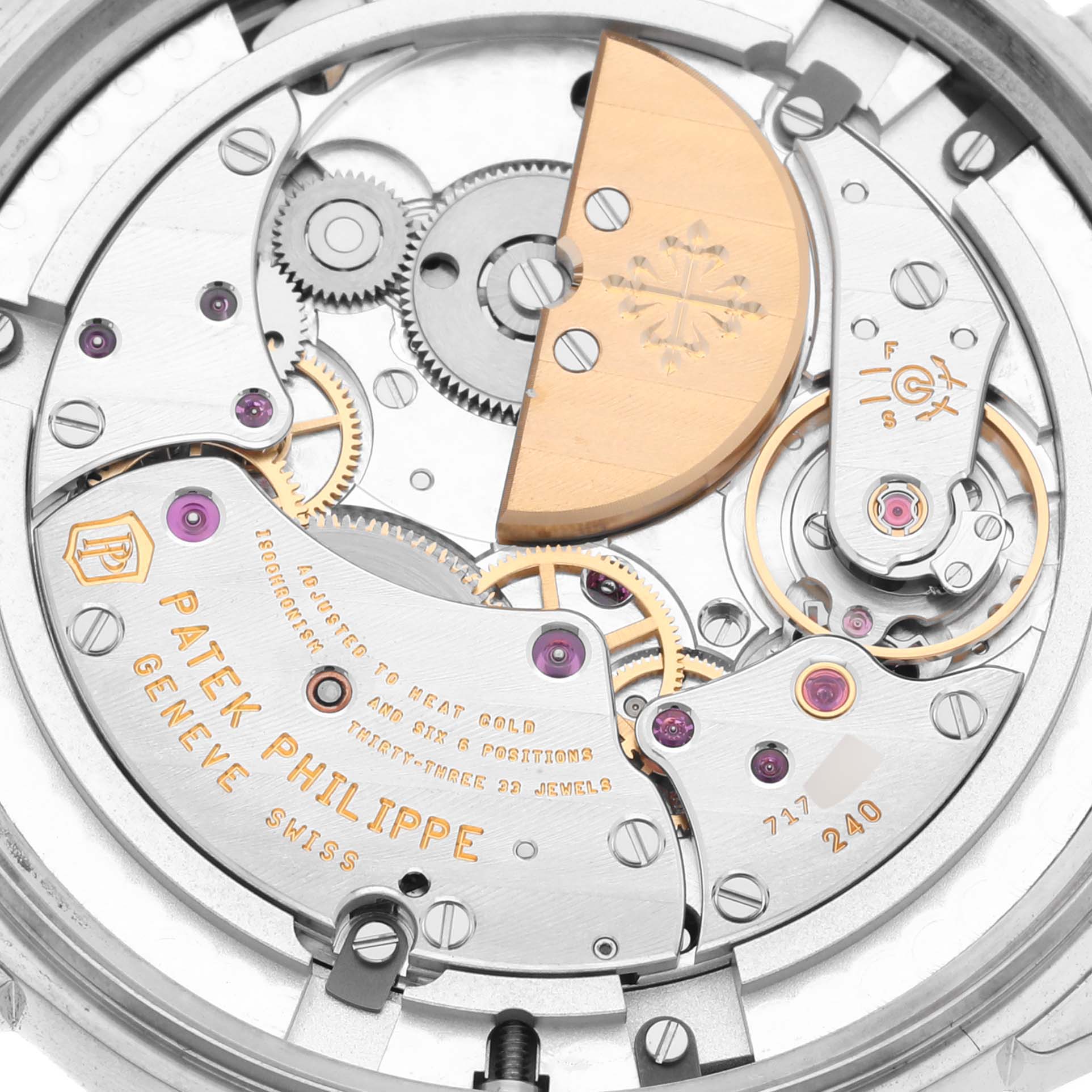 The image shows a close-up of the movement of a Patek Philippe Complications 5230G-001 Men's White Gold Grey Dial 5230G-001 Men's White Gold Grey Dial watch, highlighting its intricate gears and branding.