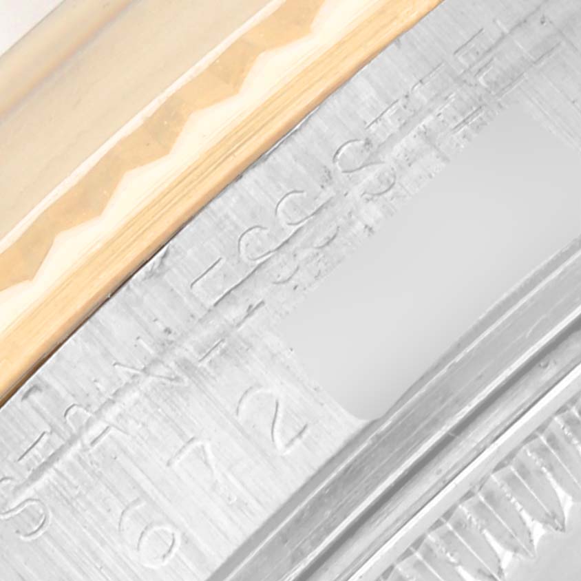 The image shows a close-up of the Rolex Vintage Collection 15003 Men's Steel and Gold (two tone) Champagne Dial 15003 Men's Steel and Gold (two tone) Champagne Dial watch's edge, highlighting engravings and part of the bezel.