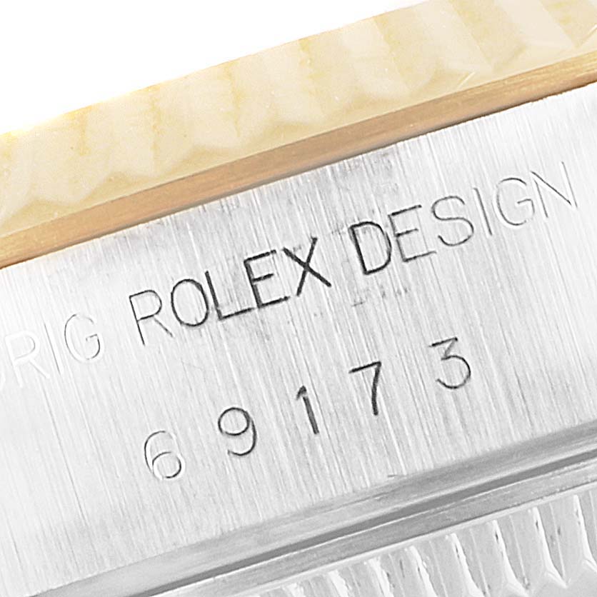 The image shows a close-up of the engraving on the side of a Rolex Datejust 69173 Women's Steel and Gold (two tone) Champagne Dial 69173 Women's Steel and Gold (two tone) Champagne Dial watch, displaying the model and serial numbers.