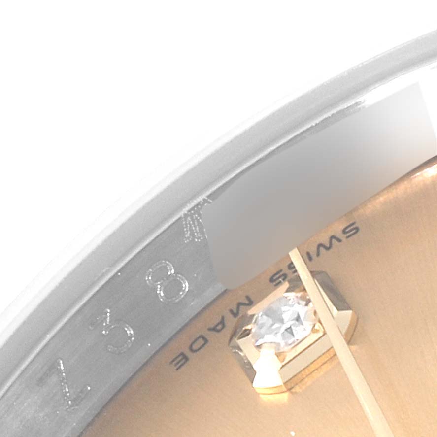 This close-up image of a Rolex Datejust 116233 Men's Steel and Gold (two tone) Champagne Dial 116233 Men's Steel and Gold (two tone) Champagne Dial watch shows part of the dial with a diamond marker and partial view of the rehaut with engravings.