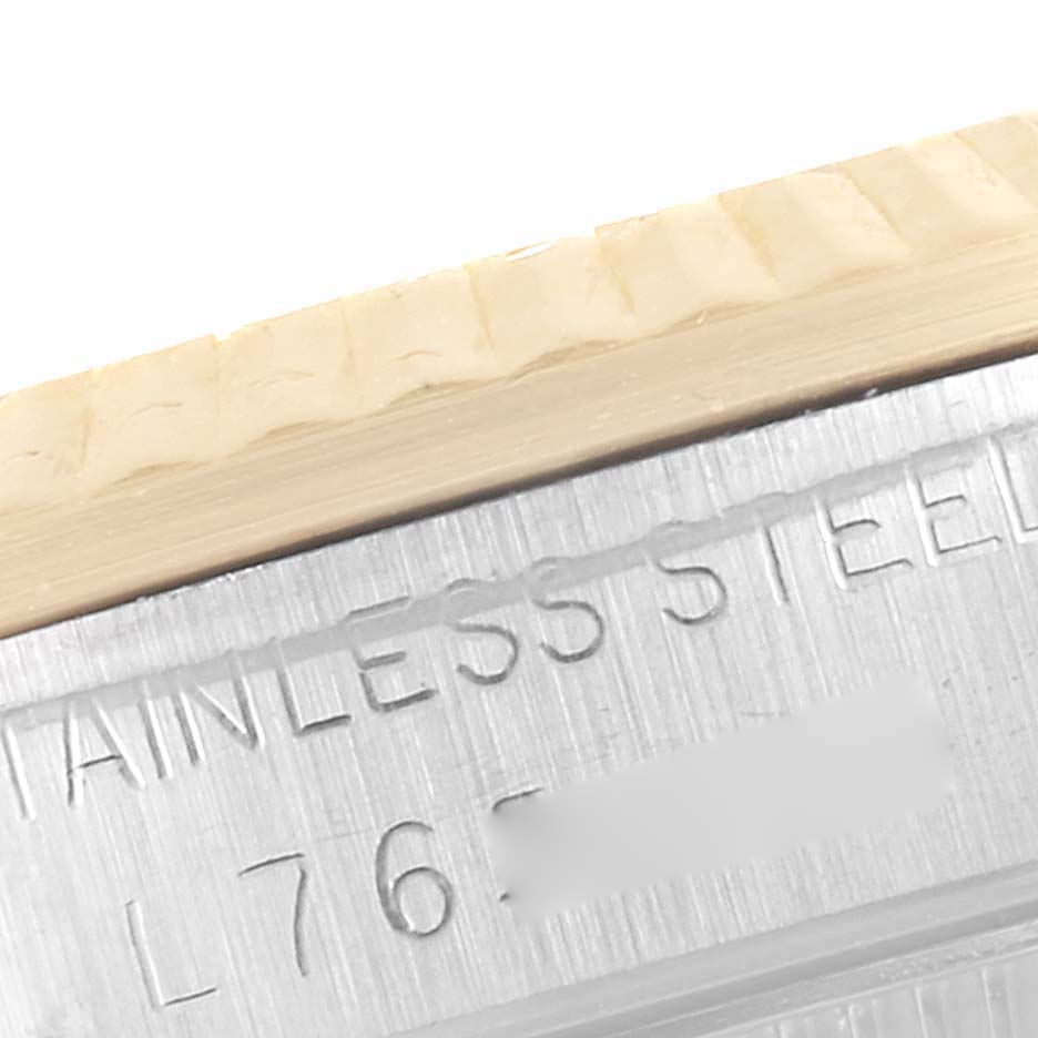 This close-up image of a Mid-Size Rolex watch displays part of the engraved stainless steel case and the bezel edge.