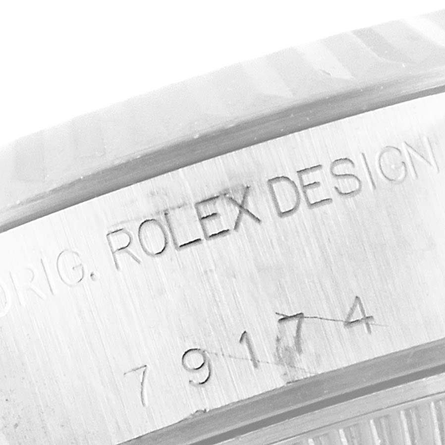The image shows an engraved case side of a Rolex Datejust 79174 Women
s Stainless Steel Silver Dial 79174 Women
s Stainless Steel Silver Dial watch with the model number 79174.