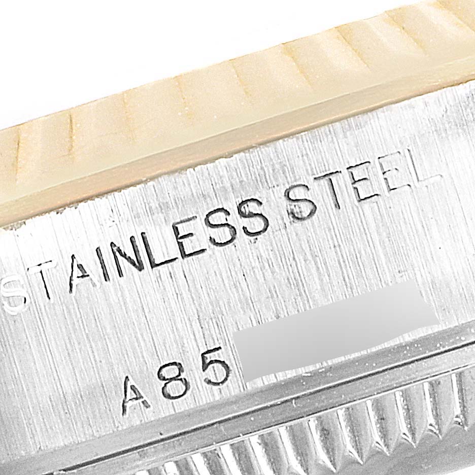 The image shows an extreme close-up of the side of a stainless steel Rolex Datejust 79173 Women's Steel and Gold (two tone) Champagne Dial 79173 Women's Steel and Gold (two tone) Champagne Dial watch case with engraving visible.