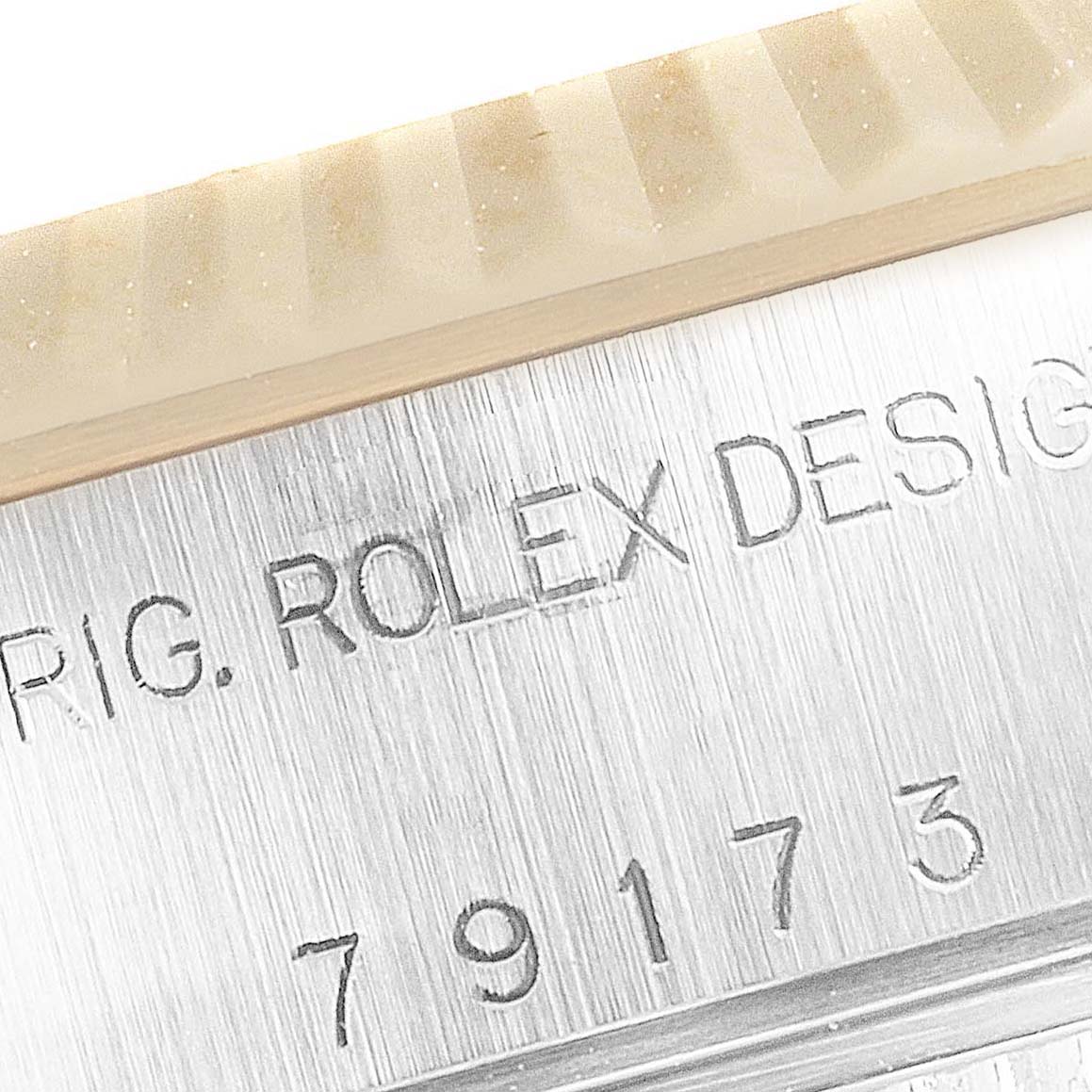 This image shows a close-up of the engraved model number and "ROLEX DESIGN" inscription on the side of a Rolex Datejust 79173 Women's Steel and Gold (two tone) Champagne Dial 79173 Women's Steel and Gold (two tone) Champagne Dial watch case.