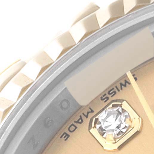 This close-up image of the Rolex Datejust 179173 Women's Steel and Gold (two tone) Champagne Dial 179173 Women's Steel and Gold (two tone) Champagne Dial watch shows part of the bezel, dial, and a diamond hour marker.
