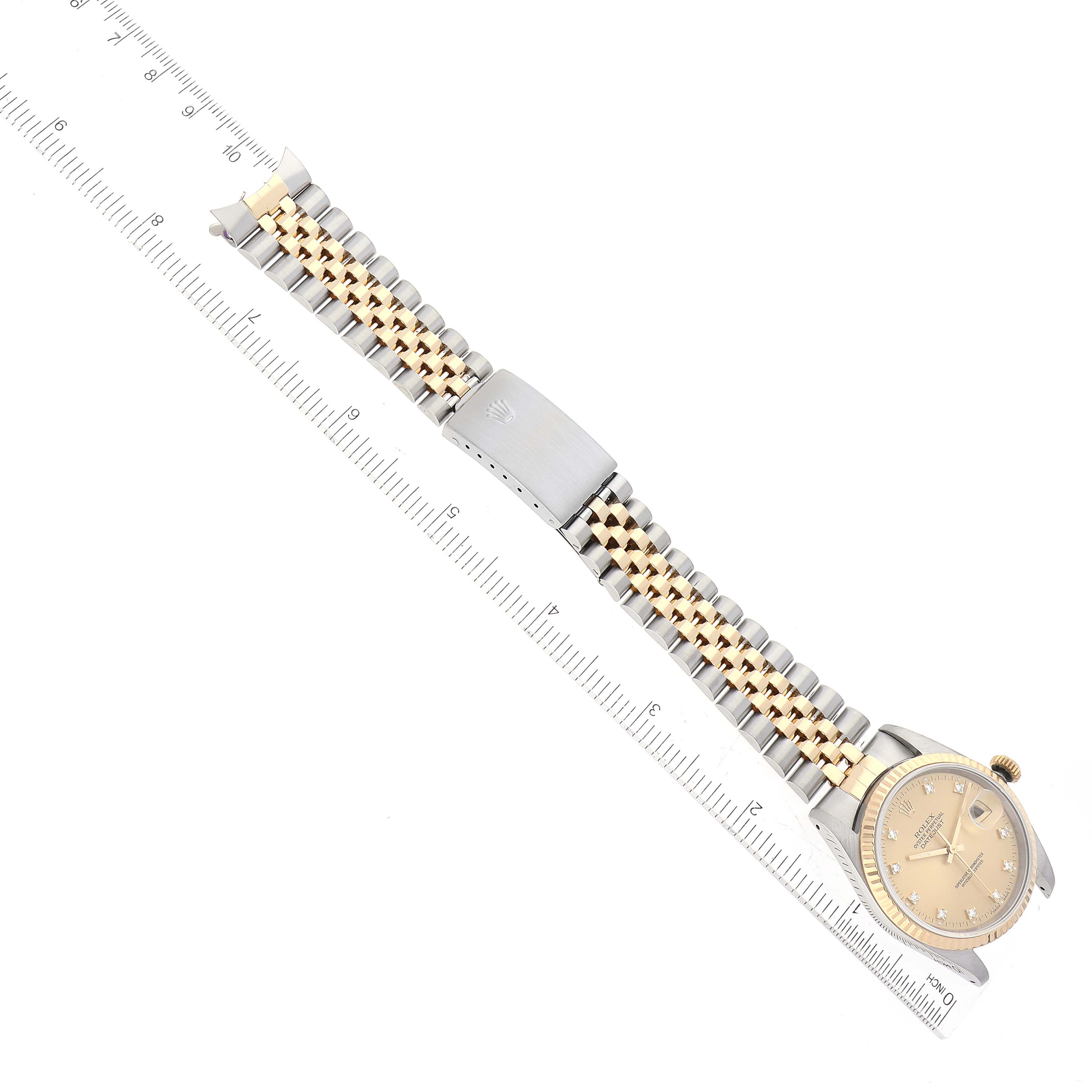 The image shows a Rolex Datejust 16233 Men's Steel and Gold (two tone) Champagne Dial 16233 Men's Steel and Gold (two tone) Champagne Dial watch from an overhead angle, highlighting the watch face and two-tone bracelet placed next to a ruler.