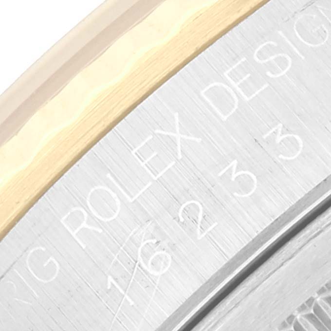 This is a close-up image of the engraved caseback edge of a Rolex Datejust 16233 Men's Steel and Gold (two tone) Champagne Dial 16233 Men's Steel and Gold (two tone) Champagne Dial watch featuring the model number and "ROLEX DESIGN" inscription.