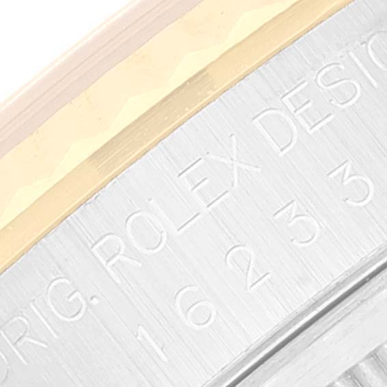The close-up image shows the engraved side of the Rolex Datejust 16233 Men
s Steel and Gold (two tone) Grey Dial 16233 Men
s Steel and Gold (two tone) Grey Dial watch case with part of the bezel visible.