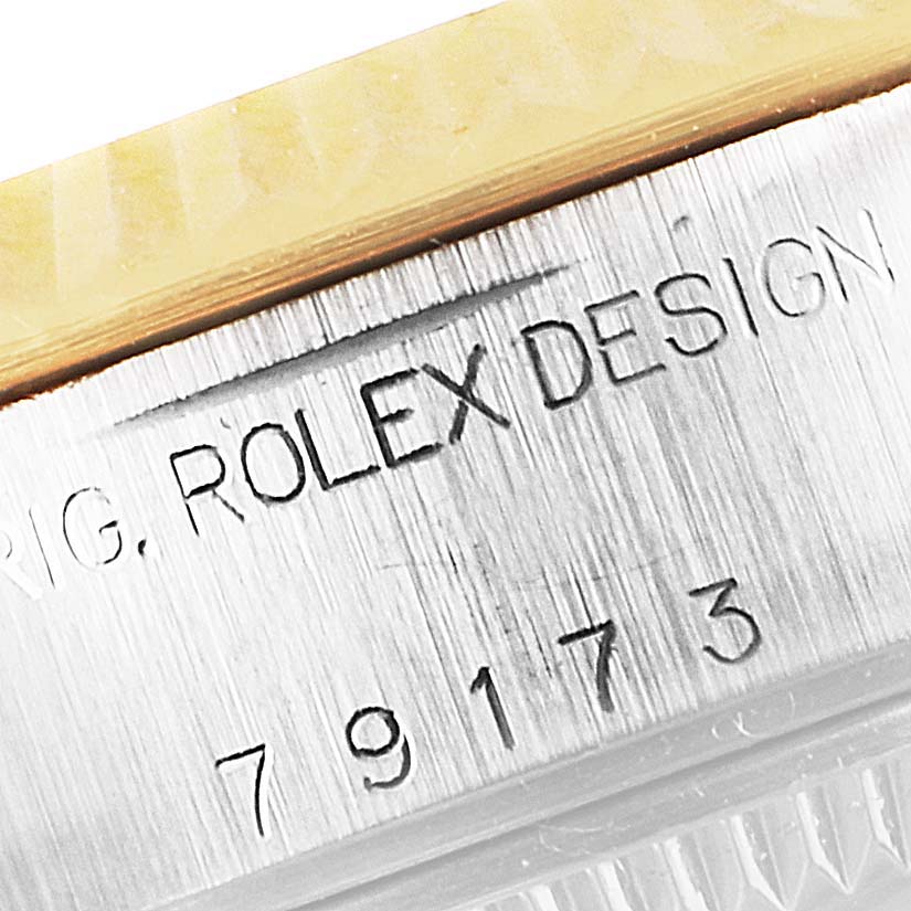This image shows a close-up of the case side engraving on a Rolex Datejust 79173 Women's Steel and Gold (two tone) White Dial 79173 Women's Steel and Gold (two tone) White Dial, highlighting the "ROLEX DESIGN" text and serial number.