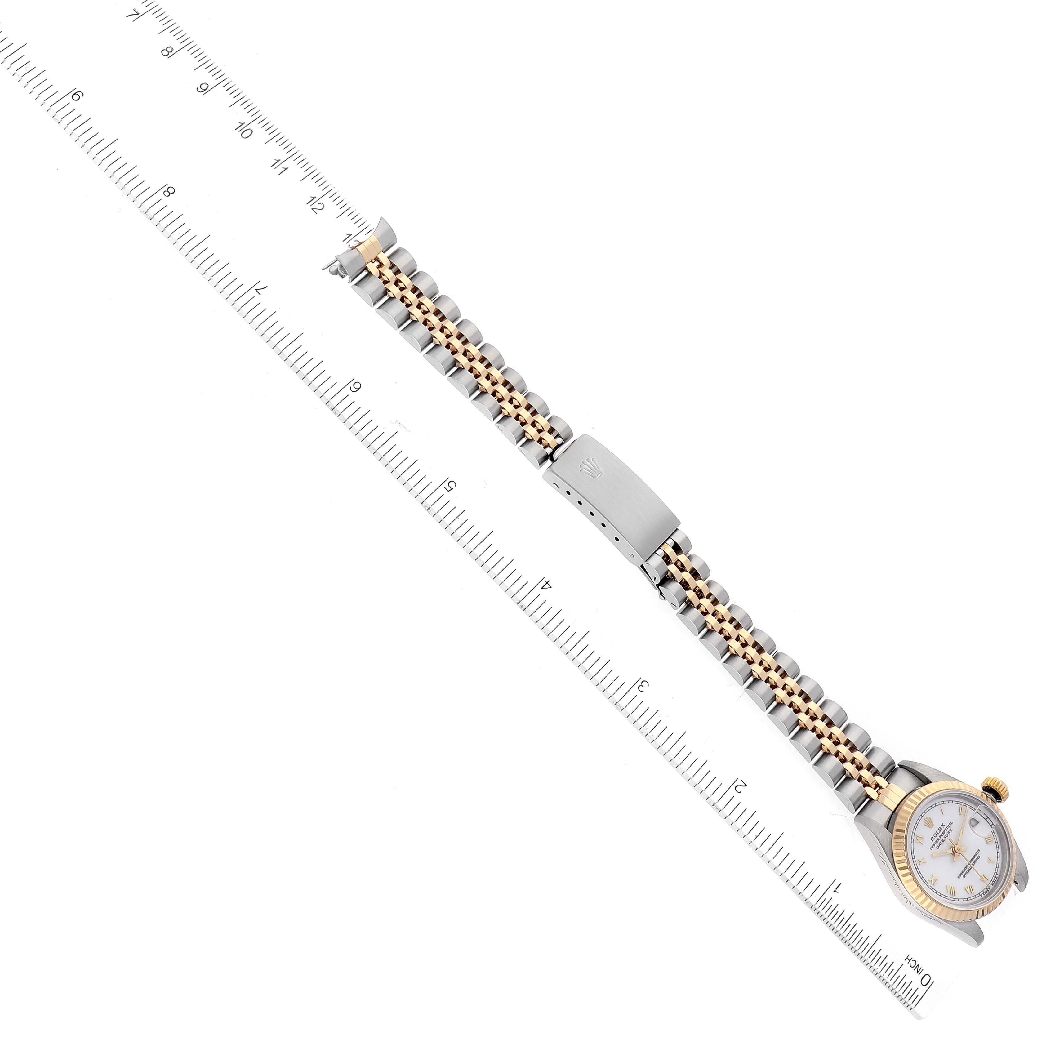 This image shows a Rolex Datejust 69173 Women's Steel and Gold (two tone) White Dial 69173 Women's Steel and Gold (two tone) White Dial watch laid flat with the dial at an angle and a ruler next to the band for measurement.