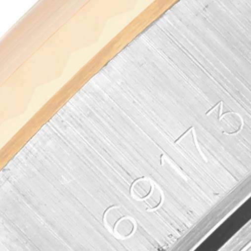 The image shows a close-up of a Rolex Datejust 69173 Women's Steel and Gold (two tone) White Dial 69173 Women's Steel and Gold (two tone) White Dial model focusing on the side of the bezel and engraved case number.