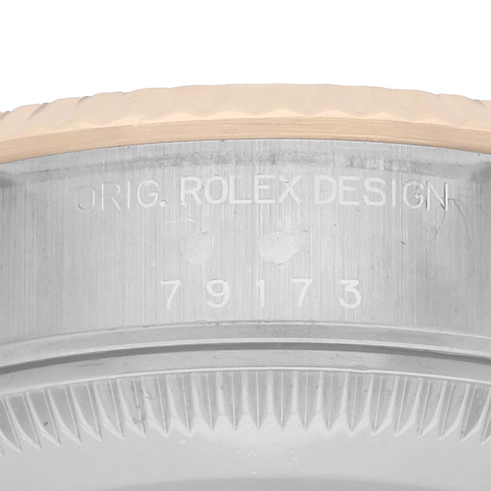 The image shows a close-up of the side case engraving on a Rolex Datejust 79173 Women
s Steel and Gold (two tone) Silver Dial, highlighting the model number and design inscription.