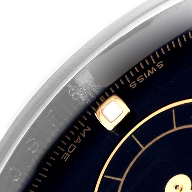 The image shows a close-up of the Rolex Daytona 116523 Men's Steel and Gold (two tone) Black Dial 116523 Men's Steel and Gold (two tone) Black Dial dial, focusing on the edge with markings and part of the face details.