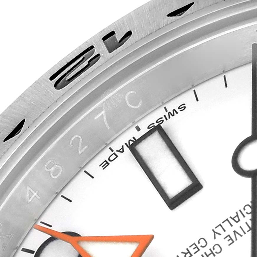 The angle shows the top-right part of the Rolex Explorer 216570 Men's Stainless Steel White Dial 216570 Men's Stainless Steel White Dial's dial, bezel, and orange second hand.