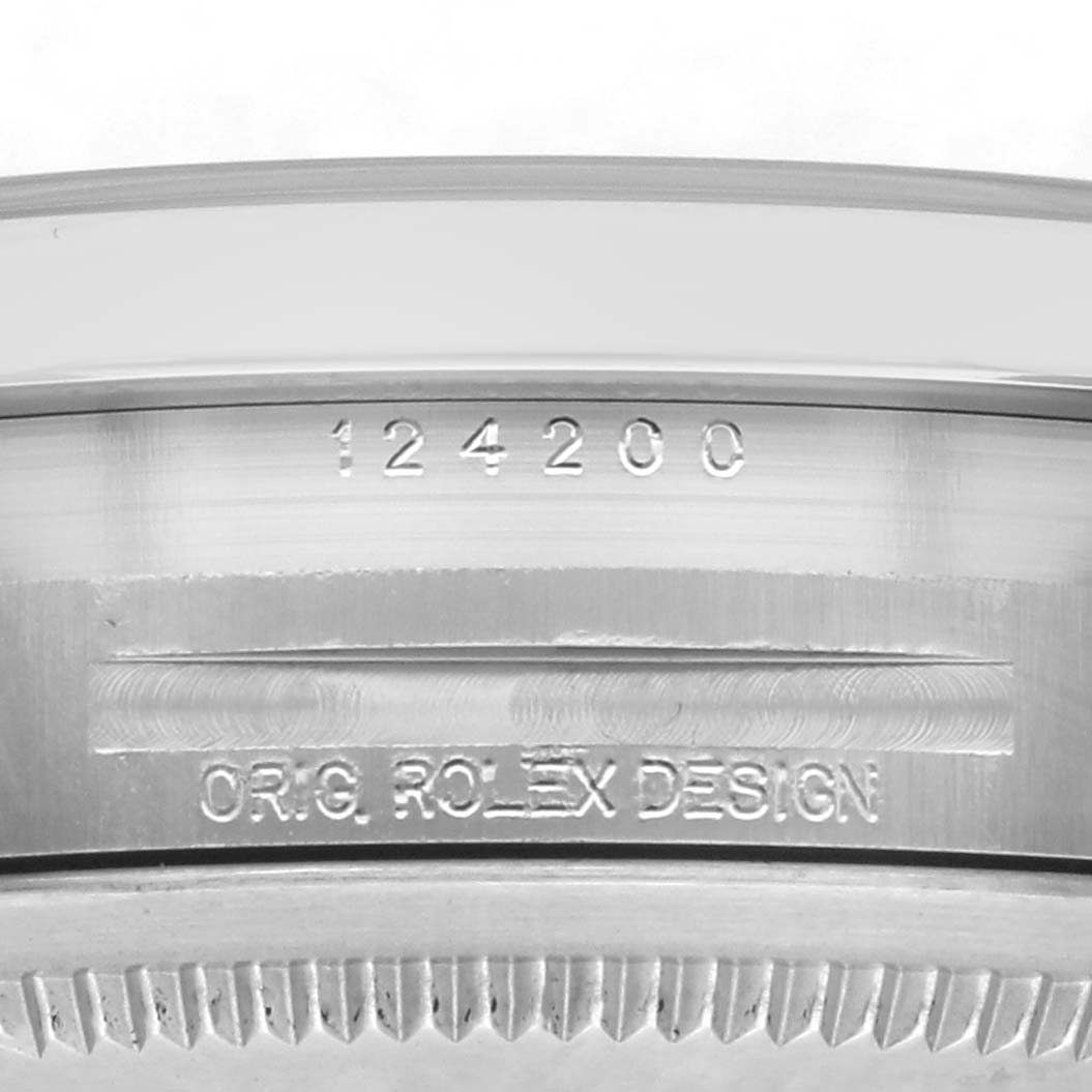 The image shows a close-up of the case side of a Rolex Oyster Perpetual 124200 Men
s Stainless Steel Silver Dial watch, focusing on the engraved model number and design label.
