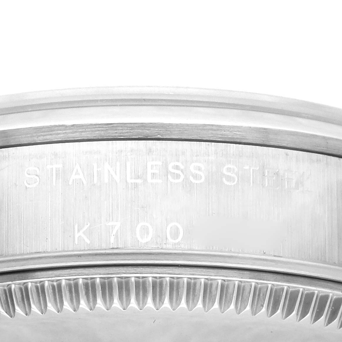 The image shows a close-up of the Rolex Mid-Size 77080 Women's Stainless Steel Silver Dial 77080 Women's Stainless Steel Silver Dial model's stainless steel case back from the edge, highlighting the engravings.