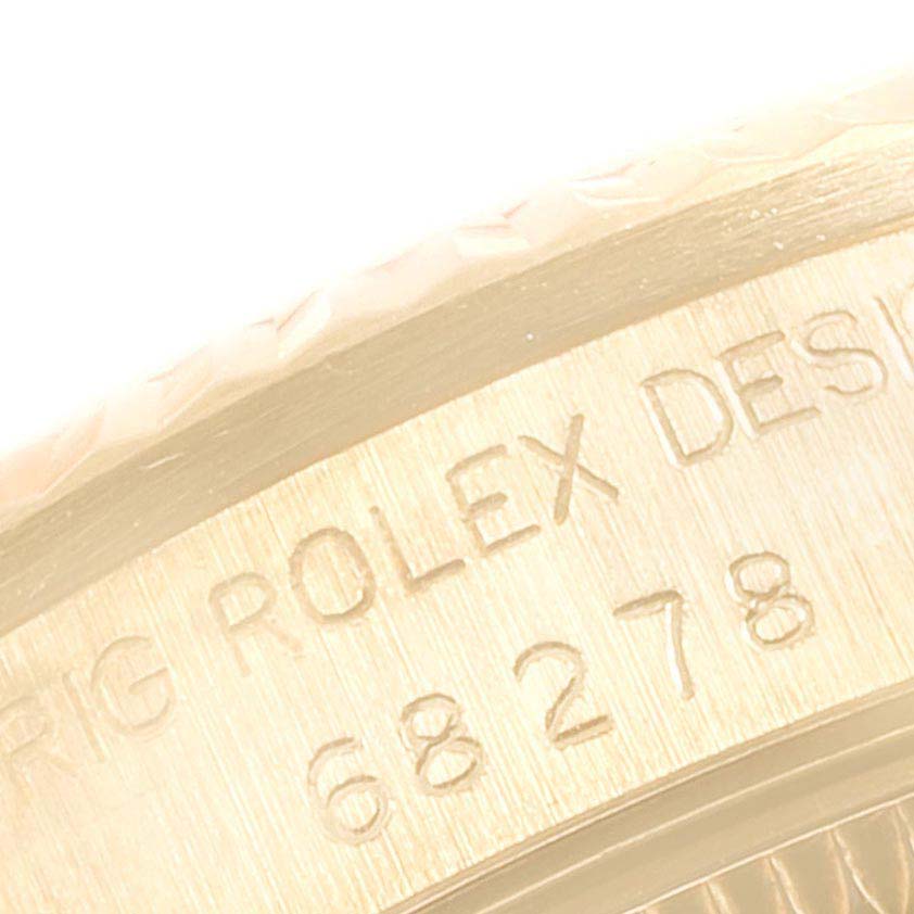 This close-up image shows the engraved text and part of the bezel of a Rolex President 68278 Women's Yellow Gold Champagne Dial 68278 Women's Yellow Gold Champagne Dial model watch.