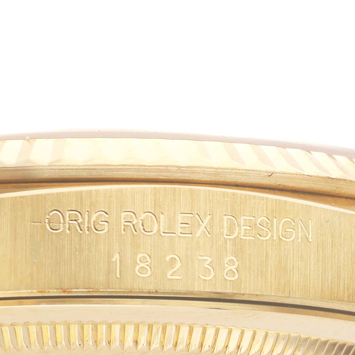 The image shows a close-up of the side engraving on a Rolex President 18238 Men
s Yellow Gold Champagne Dial 18238 Men
s Yellow Gold Champagne Dial watch, highlighting "ORIG ROLEX DESIGN 18238".