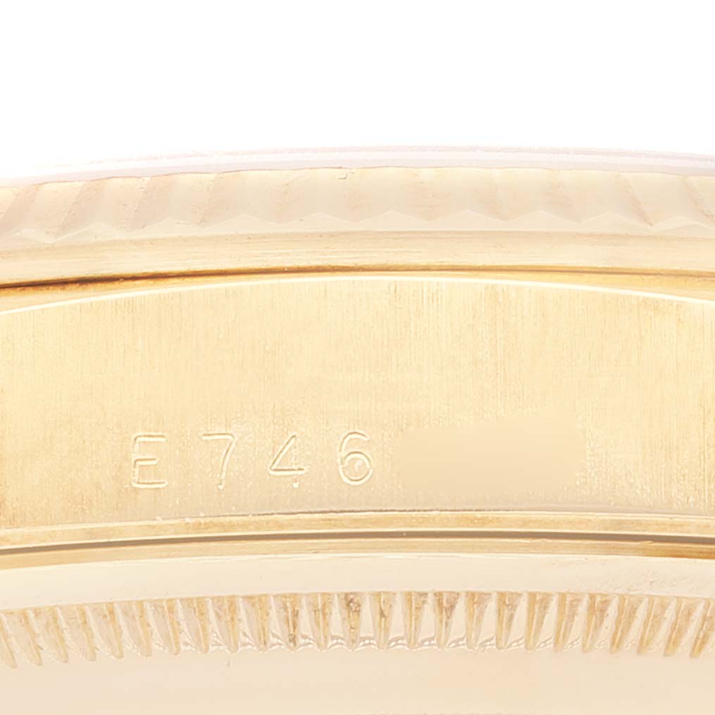 This image shows a close-up of the side of a Rolex President 18238 Men's Yellow Gold Champagne Dial 18238 Men's Yellow Gold Champagne Dial watch, focusing on the serial number engraving and part of the bezel.