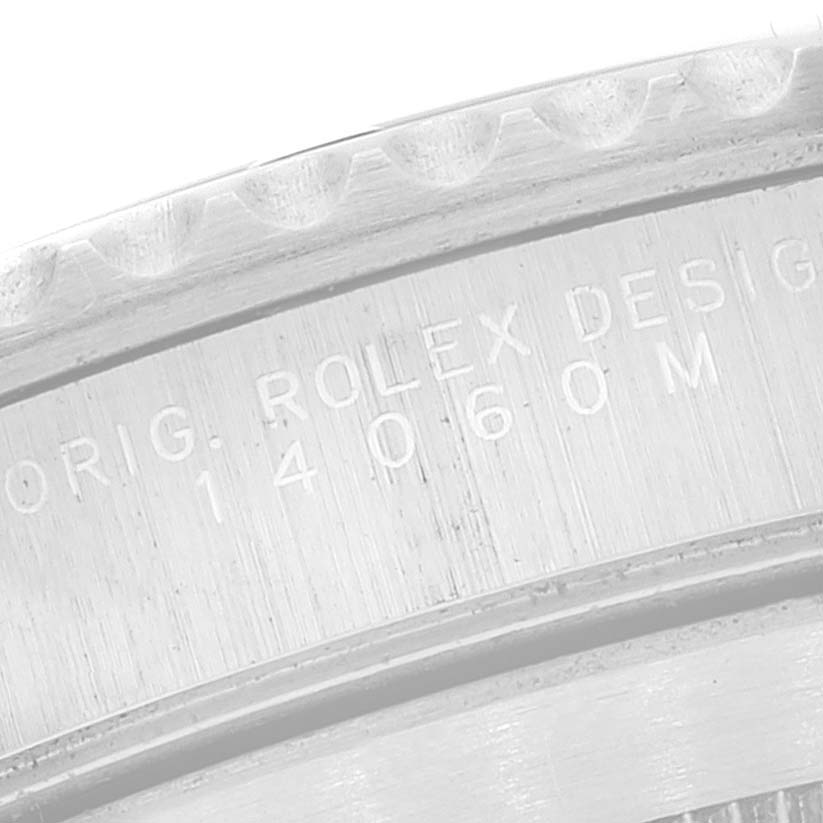 The image shows a close-up of the outer rim of a Rolex Submariner 14060 Men
s Stainless Steel Black Dial 14060 Men
s Stainless Steel Black Dial watch case with the model number 14060M engraved.