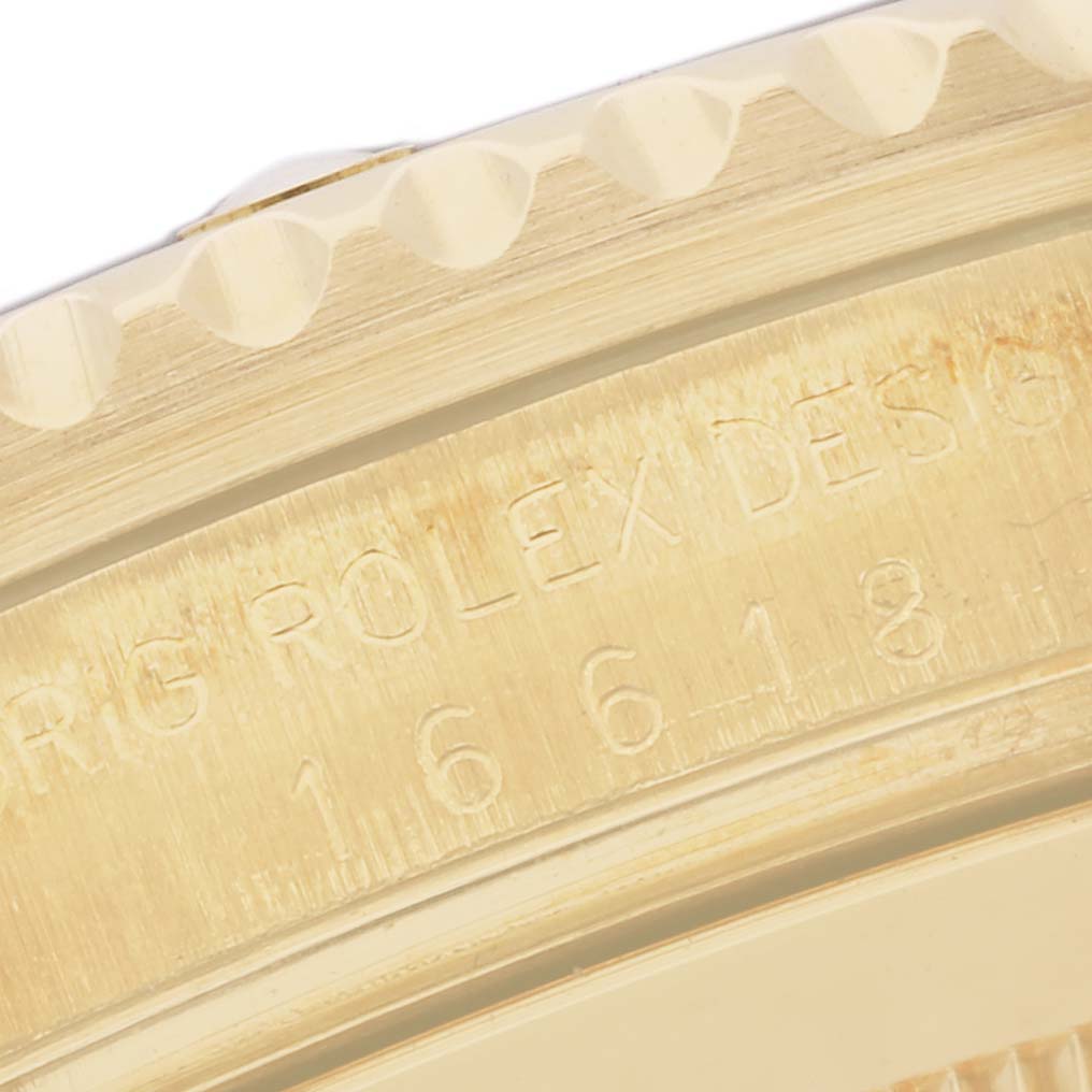 The image shows a close-up of the side engraving and ridged bezel of a Rolex Submariner 16618 Men's Yellow Gold Black Dial 16618 Men's Yellow Gold Black Dial watch.