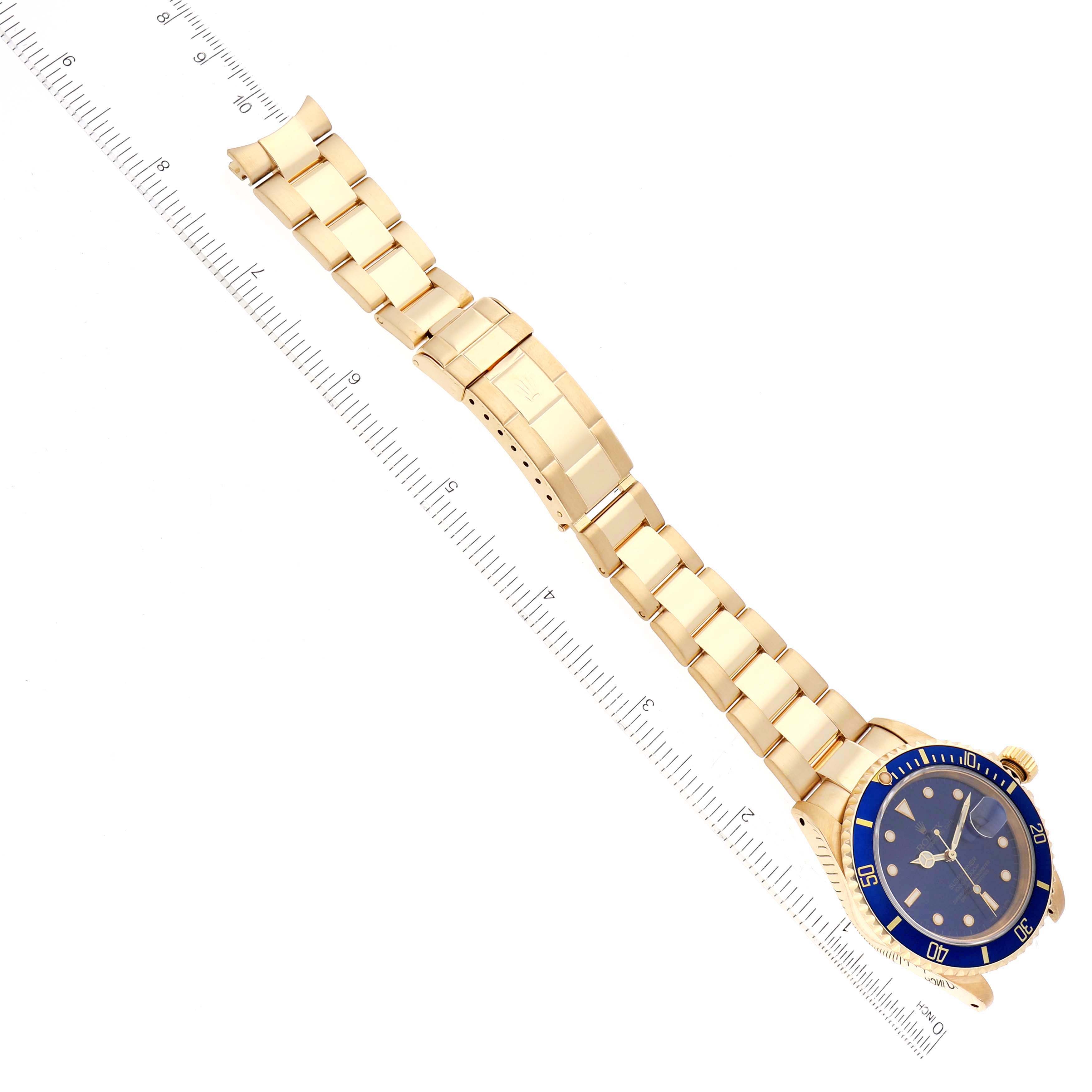 The Rolex Submariner 16618 Men's Yellow Gold Blue Dial is shown from a top-down angle, highlighting its full bracelet, dial, and bezel.