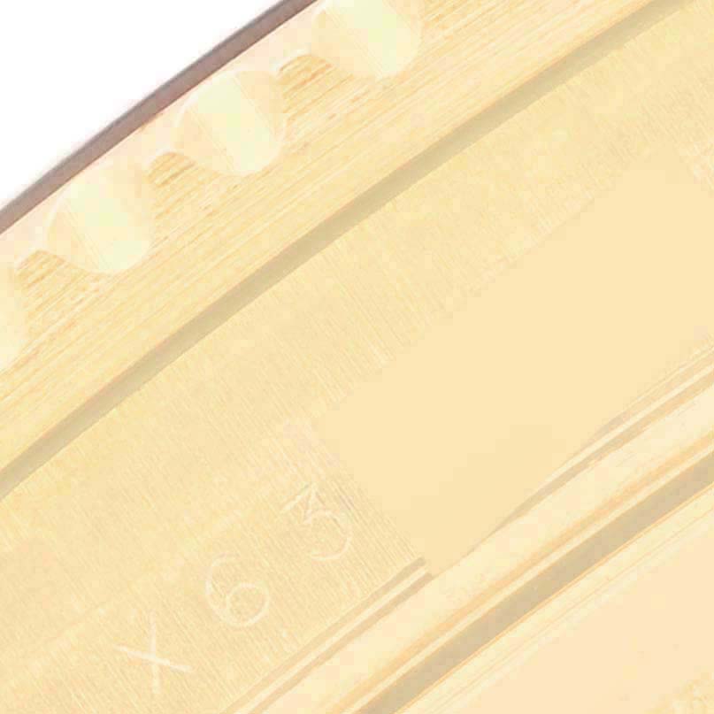 The image shows a close-up of the edge of the bezel of a Rolex Submariner 16618 Men's Yellow Gold Blue Dial watch with part of the detailing visible.