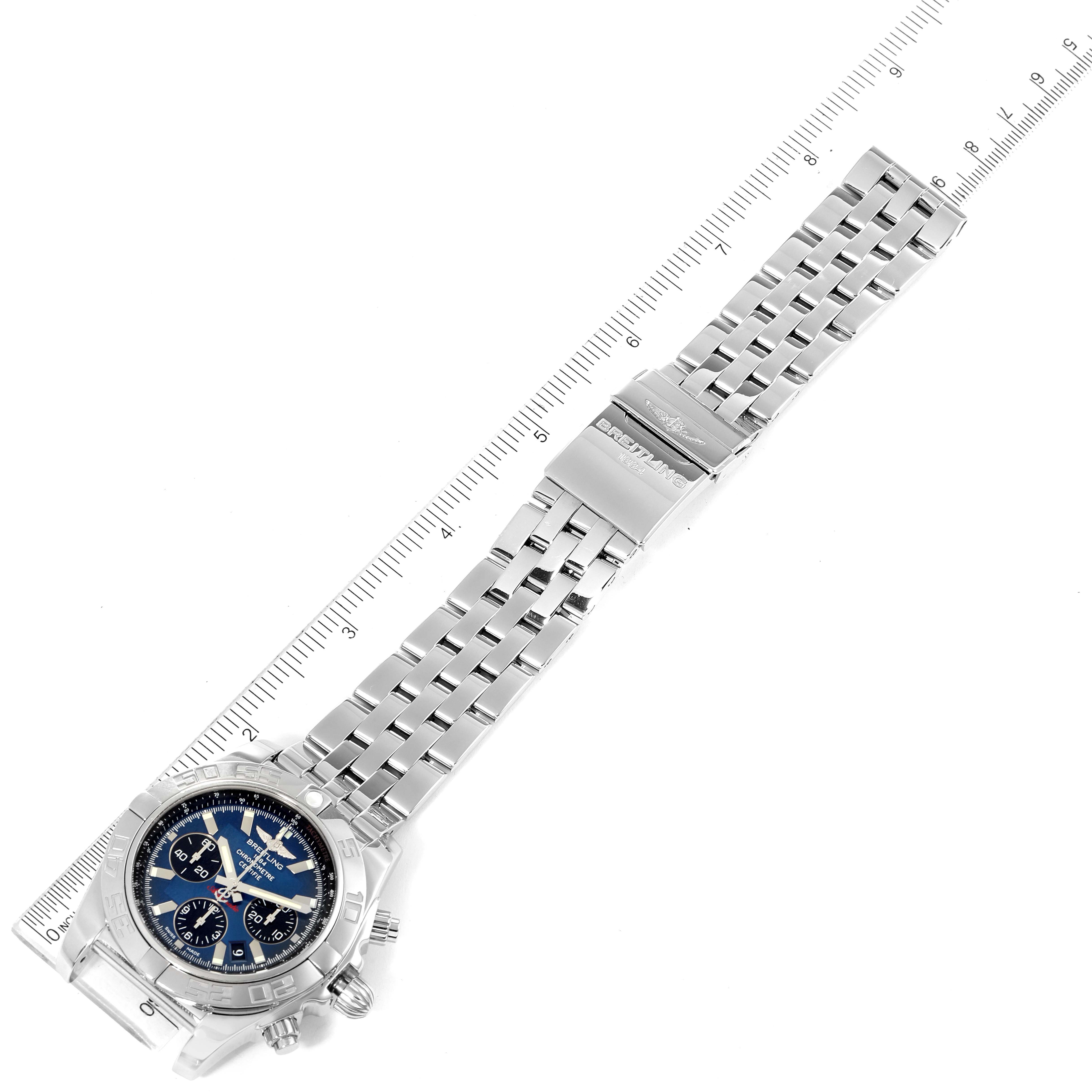 The image shows an overhead view of a Breitling Chronomat AB0110 Men
s Stainless Steel Blue Dial AB0110 Men
s Stainless Steel Blue Dial watch with a metal bracelet and clasp, accompanied by a ruler for measurement.